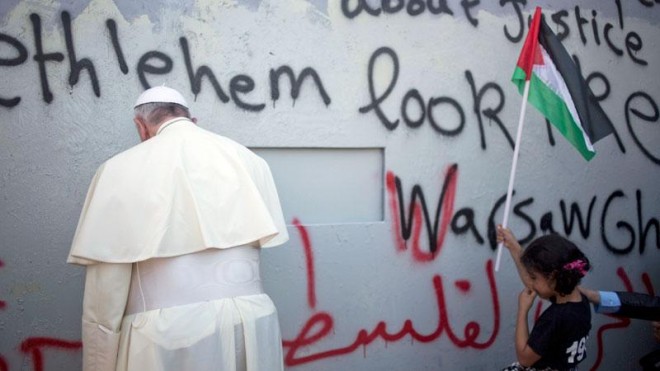 Pope Francis prays for peace at a wall that separates Israel and Palestine