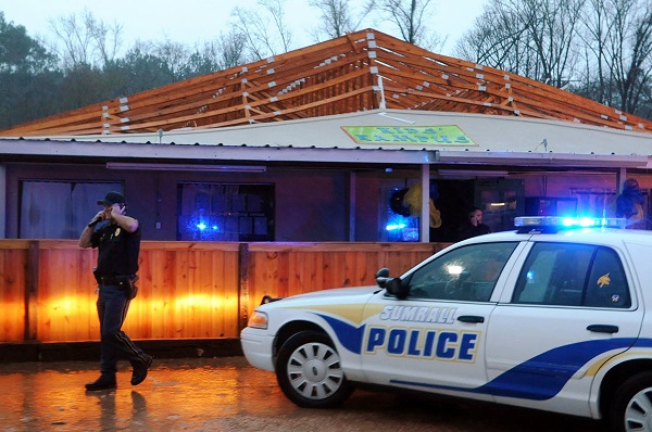 Police inspect Kid's Kampus, a daycare facility after a tornado ripped the roof off of the building in Sumrall, Miss., Tuesday, Dec. 23, 2014. According to the Sumrall Police Department, all 30 children and employees were unharmed and moved to the neighboring Citizens Bank. AP