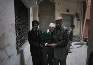 The uncle and cousin of injured student Mohammad Baqair, center, comfort him as he mourns the death of his mother who was a teacher at the school which was attacked by Taliban, in Peshawar, Pakistan, Tuesday, Dec. 16, 2014. Taliban gunmen stormed a military-run school in the northwestern Pakistani city of Peshawar on Tuesday, killing more than 100, officials said, in the highest-profile militant attack to hit the troubled region in months. (AP Photo/Mohammad Sajjad)