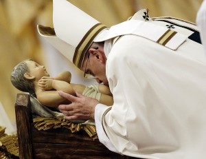 Pope Francis kisses a statue of Baby Jesus as he celebrates the Christmas Eve Mass in St. Peter's Basilica at the Vatican, Wednesday, Dec. 24, 2014. Pope Francis celebrated Christmas Eve with a late-night Mass Wednesday in St. Peter's Basilica and a phone call to some Iraqi refugees forced to flee their homes by Muslim militants. Francis told refugees at the tent camp in Ankawa, a suburb of Irbil in northern Iraq, that they were like Jesus, forced to flee because there was no place for them. For Christians, Christmas marks the birth of Jesus in a Bethlehem barn manger, chosen because there was no room for his parents at an inn. AP