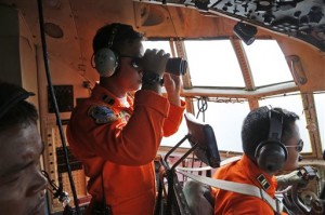 A crew of an Indonesian Air Force C-130 airplane of the 31st Air Squadron uses a binocular to scan the horizon during a search operation for the missing AirAsia flight 8501 jetliner over the waters of Karimata Strait in Indonesia, Monday, Dec. 29, 2014. Search planes and ships from several countries on Monday were scouring Indonesian waters over which an AirAsia jet disappeared, more than a day into the region's latest aviation mystery. AirAsia Flight 8501 vanished Sunday in airspace thick with storm clouds on its way from Surabaya, Indonesia, to Singapore. (AP Photo/Dita Alangkara)