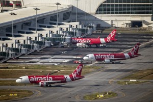 CORRECTS NUMBERS OF PASSENGERS ON BOARD - In this Nov 26, 2014 photo, AirAsia Airbus A320-200 passenger jets are parked on the tarmac at low cost terminal KLIA2 in Sepang, Malaysia. An AirAsia plane with 162 people on board lost contact with ground control on Sunday, Dec. 28, 2014, while flying over the Java Sea after taking off from a provincial city in Indonesia for Singapore, and search and rescue operations were underway. The planes in this photo are not the plane that went missing while flying from Indonesia to Singapore but one of the same models. (AP Photo/Vincent Thian)