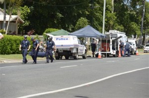 Police carry equipment near a road block outside a house where eight children have been found dead in the Cairns suburb of Manoora, Australia, Friday. (AP Photo)