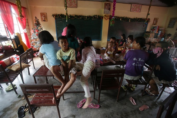 Evacuees stay inside a school as Typhoon Hagupit affects Legazpi, Albay province, eastern Philippines on Sunday, Dec. 7, 2014. Typhoon Hagupit slammed into the central Philippines' east coast late Saturday, knocking out power and toppling trees in a region where 650,000 people have fled to safety, still haunted by the massive death and destruction wrought by a monster storm last year. AP