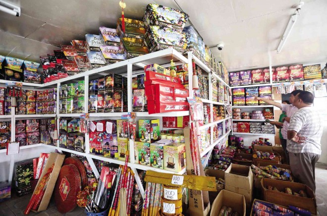 Early birds select fireworks in a licensed fireworks shop in Barangay Turo, Bocaue, Bulacan. Owner Annie Dinglasan says business has rapidly increased since the first week of December. LYN RILLON 
