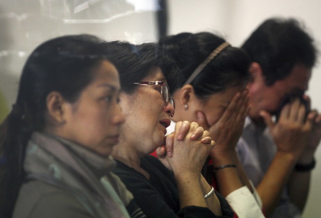 Relatives and next-of-kin of passengers on the AirAsia flight QZ8501 wait for the latest news on the search of the missing jetliner at Juanda International Airport in Surabaya, East Java, Indonesia, Monday, Dec. 29, 2014.  AP PHOTO/TRISNADI MARJAN 