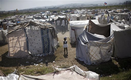 FILE -  This Feb. 13, 2010, file photo shows a child standing among makeshift tents at a refugee camp for earthquake survivors in the Cite Soleil neighborhood of Port-au-Prince. A few hours before 19-year-old Britney Gengel was buried alive in the earthquake, she texted her parents her last dream: "I want to move here and start an orphanage." Nearly five years later Gengel's father is fulfilling the dream of his late daughter. (AP Photo/Rodrigo Abd, File)