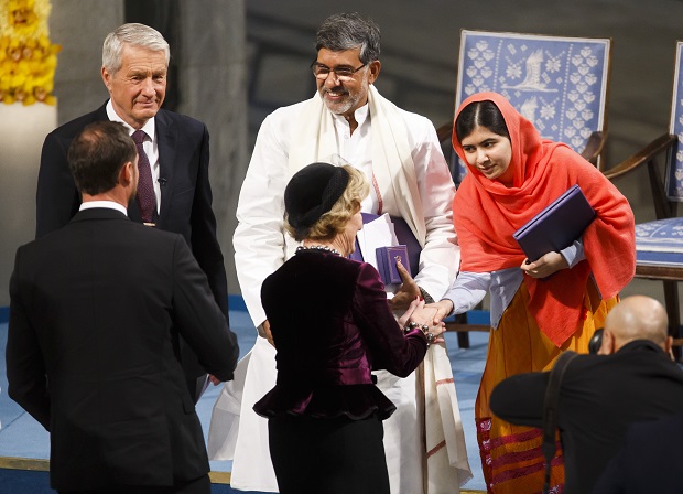 Nobel Peace prize laureate Malala Yousafzai, right, shakes hands Queen Sonja of Norway, with fellow laureate Kailash Satyarthi, centre, Wednesday Dec. 10, 2014 in Oslo City Hall. Malala Yousafzai and Kailash Satyarthi both received the Nobel Peace Prize on Wednesday, both have campaigned for the rights of children and young people. (AP Photo / Heiko Junge, NTB scanpix) NORWAY OUT