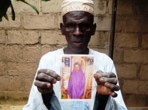 Sani Garba, 55, holds the picture of his 14-year-old daughter-in-law Wasila Tasi'u on August 10, 2014 inside her abandoned matrimonial home in the village of Unguwar Yansoro, 63 kilometres outside the northern Nigerian city of Kano. AFP
