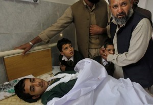 A Pakistani man comforts a student standing at the bedside of a boy who was injured in a Taliban attack on a school, at a local hospital in Peshawar, Pakistan, Tuesday, Dec. 16, 2014. Taliban gunmen stormed a military-run school in the northwestern Pakistani city of Peshawar on Tuesday, killing and wounding scores, officials said, in the worst attack to hit the country in over a year.(AP Photo/Mohammad Sajjad)