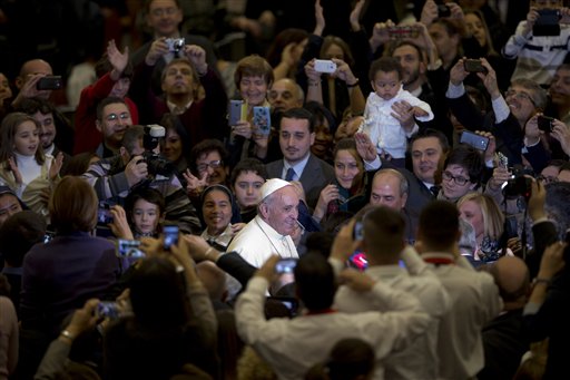 Pope Francis is cheered by faithful during an audience with the Holy See's employees in the Paul VI hall at the Vatican, Monday, Dec. 22, 2014. AP