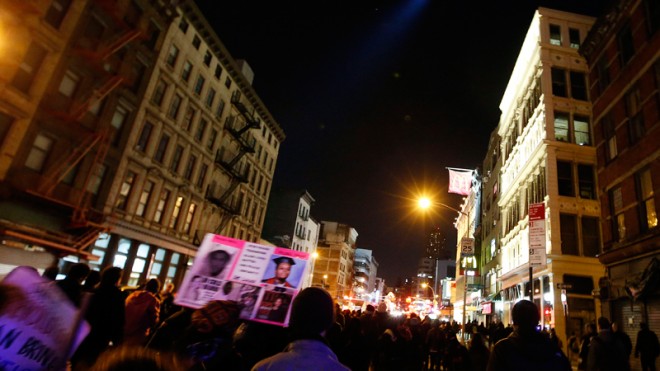 A police helicopter shines a light on a group of protesters rallying against a grand jury's decision not to indict the police officer involved in the death of Eric Garner as they march along Canal Street in the early morning hours of Thursday, Dec. 4, 2014, in New York. (AP Photo/Jason DeCrow)