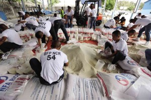 FIREMEN PITCH IN Members of Bureau of Fire Protection help in repacking rice for  victims of Typhoon "Ruby" at a warehouse of the Department of Social Welfare and Development in Parañaque.