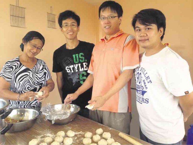 TAIWANESE social workers Liu Ming-hao and Yao Fen-zhi (in the middle), help volunteers of Bukluran Multipurpose Cooperative train poor women in starting up a small business of “baozhi” and shortcake-making in Cavite. MARICAR CINCO 
