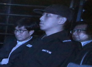 In this photo taken through a tinted glass, Thomas Kwok, right, co-chairman of Hong Kong developer Sun Hung Kai Properties, and Sun Hung Kai Properties Executive Director Thomas Chan Kui-yuen, left, are escorted by a staff member from Hong Kong Correctional Services inside a van outside the High Court in Hong Kong, Friday, Dec. 19, 2014.  AP