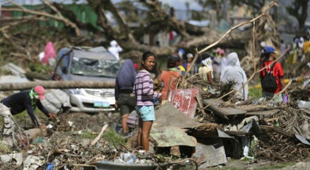 A typhoon survivor stands on rubbish in Tacloban, central Philippines on Sunday, Dec. 8, 2013. AP FILE PHOTO