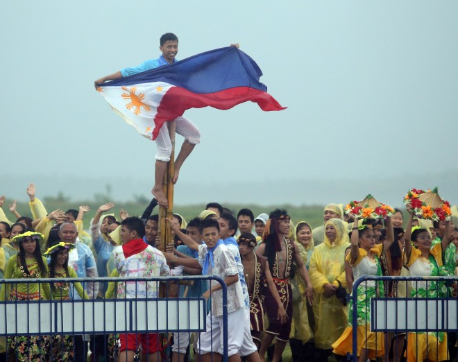 Unidentified student waves a flag of the Philippines as Pope Francis gets off from the PAL airplane RP-C8618 in Tacloban. CDN