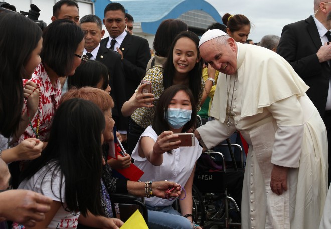 Pope Francis poses for a selfie with some women upon his arrival at Villamor Air Base in Pasay City from Tacloban on Saturday, January 17, 2015. The Pope's trip to Leyte was cut short due to bad weather brought by Tropical Storm Amang.(REY S. BANIQUET/NIB)