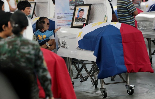 A child touches the coffin of one of the Special Action Forces (SAF) troopers who perished in the Mamasapano, Maguindanao incident during the necrological services at Camp Bagong Diwa in Taguig City on Friday. GRIG C. MONTEGRANDE/INQUIRER