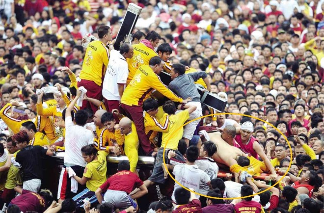 RUSH OF DEVOTION A man (encircled, top photo) is knocked unconscious on the carriage bearing the Black Nazarene image as it inches its way through the crushing waves of devotees, including those needing stretchers