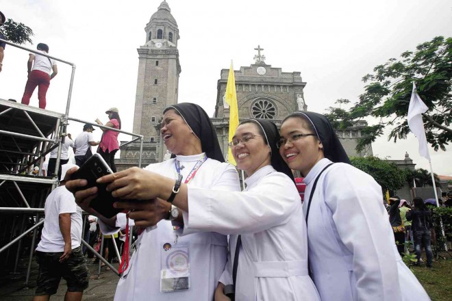 SELFIE SISTERS  A group of nuns take a selfie using Manila Cathedral as backdrop during their long wait for the Pope who was to celebrate Mass for the clergy and members of the religious on Friday morning. ARNOLD ALMACEN 