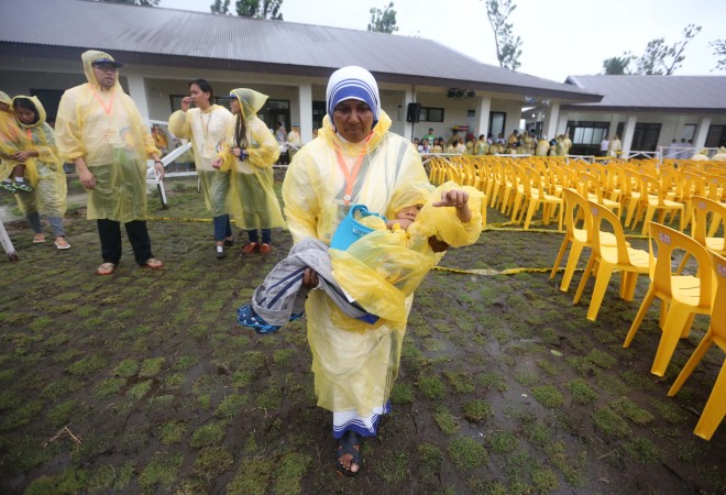 A nun carries a child with disabilities towards their designated seats at the Pope Francis Center in Gonzaga House/Archbishop's Palace, Palo, Leyte. The Pope was unable to attend the full ceremonies here and left earlier for Manila due to bad weather conditions. INQUIRER PHOTO/LYN RILLON