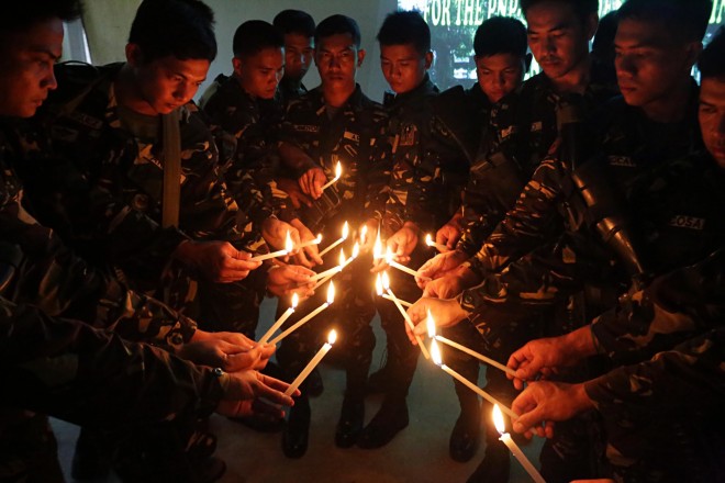 Soldiers from the Philippine Army's 2nd Infantry Battalion in Ligao City, offer prayers and light candles for the death of the 44 members of the Philippine National Police-Special Action Force, who were killed in Mamasapano, Maguindanao last January 25. MARK ALVIC ESPLANA/INQUIRER SOUTHERN LUZON