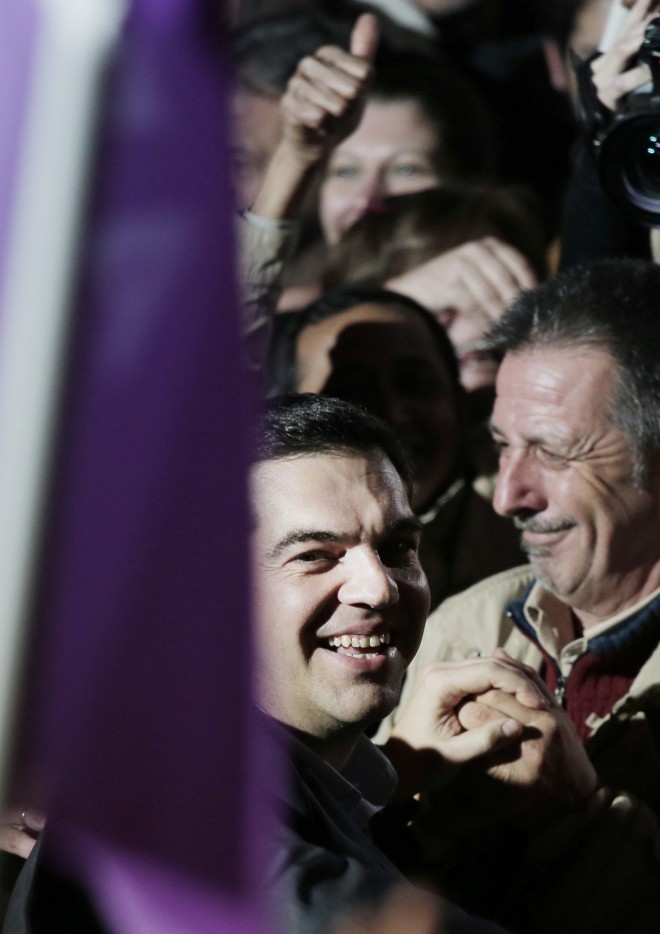 Alexis Tsipras, center, leader of Greece's Syriza left-wing main opposition party surrounded by supporters arrives at the headquarters of his party in Athens, Sunday, Jan. 25, 2015. The anti-bailout Syriza party won a decisive victory in Greece's national elections, according to projections by state-run TV's exit poll, in a historic first for a radical left-wing party in Greece.  AP PHOTO/LEFTERIS PITARAKIS 