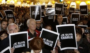 People hold posters reading 'I am Charlie' as they gather to express solidarity with those killed in an attack at the Paris offices of weekly newspaper Charlie Hebdo, in Nice, southeastern France, Wednesday, Jan. 7, 2015. Three masked gunmen shouting “Allahu akbar!” stormed the Paris offices of a satirical newspaper Wednesday, killing 12 people, including its editor, before escaping in a car. It was France's deadliest postwar terrorist attack. (AP Photo/Lionel Cironneau)