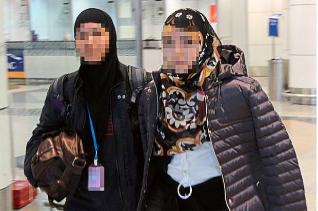 Caught in dragnet: A woman officer from the Bukit Aman Special Branch Counter Terrorism Division escorting the 27-year-old university dropout .