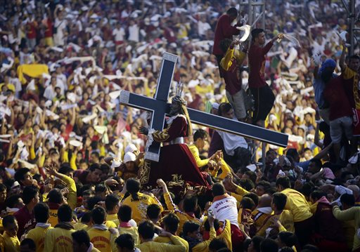 Filipino devotees carry the image of the Black Nazarene for its annual procession to celebrate its feast day Friday, Jan. 9, 2015 in Manila, Philippines. The raucous celebration drew tens of thousands of devotees in a barefoot procession around Manila streets.  AP 