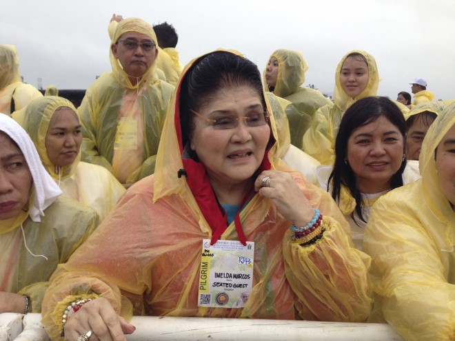 Former first lady and now Rep. Imelda Marcos wears a yellow raincoat as she attends a mass in the highlight of Pope Francis' pastoral visit to the country Saturday, Jan. 17, 2015 at Tacloban, Leyte. Marcos also hails from Leyte. AP