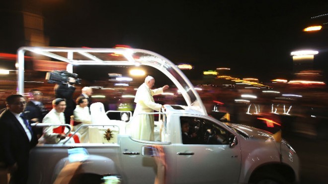 Pope Francis waves to Filipinos as he rides his Popemobile back to the Apostolic Nunciature after attending the "Meeting with Families" in Manila, Philippines on Friday, Jan. 16, 2015. (AP Photo/Aaron Favila)