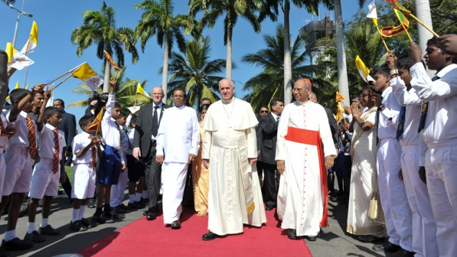 Pope Francis, center, arrives at Colombo's International airport, Sri Lanka, Tuesday, Jan. 13, 2015. The pontiff arrived in Sri Lanka Tuesday at the start of a weeklong Asian tour saying the island nation can't fully heal from a quarter-century of ethnic civil war without pursuing truth for the injustices committed. (AP Photo/L'Osservatore Romano, pool)