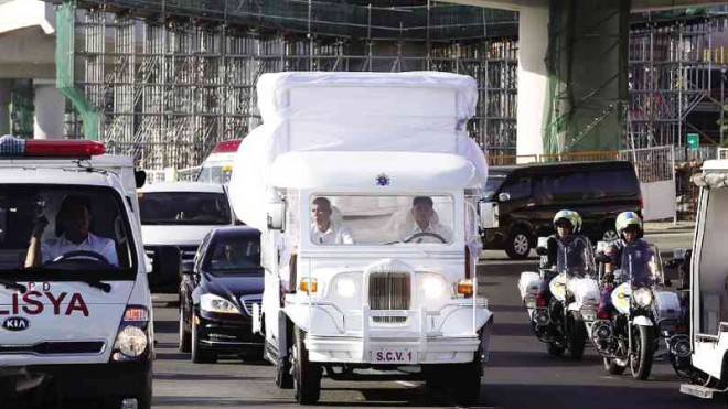 A white jeepney, one of the three popemobiles to be used by Pope Francis for his visit to the country, arrives under heavy guard at Villamor Air Base in Pasay City for a dry run for his arrival on Jan. 15.  NIÑO JESUS ORBETA
