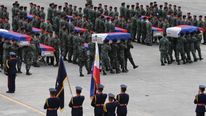 The Philippine National Police Special Action Forces carry the flag-draped coffins of their comrades upon arrival from the southern Philippines Thursday, Jan. 29, 2015 at Villamor Air Base in Pasay, Philippines. The flag-draped coffins bearing the bodies of 42 of the 44 policemen killed last Sunday were flown Thursday to Manila, where top government, police and military officials stood in mourning. (AP Photo/Bullit Marquez)