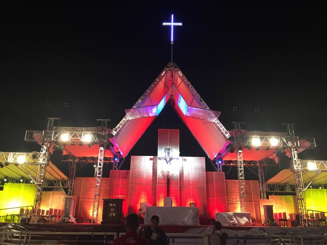 The "sawali" stage where Pope Francis will hold mass is bathed in red and yellow a night before the papal mass. Photo by Marc Jayson Cayabyab