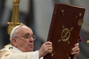 Pope Francis lifts the Holy Book as he celebrates a Mass to mark Epiphany, in St. Peter's Basilica, at the Vatican, Tuesday, Jan. 6, 2015. AP