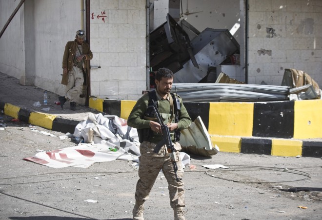 Houthi Shiite Yemeni wearing an army uniform stand guard in front of a building damaged during recent clashes near the presidential palace in Sanaa, Yemen, Tuesday, Jan. 20, 2015. Shiite militiamen seized the presidential palace in Yemen's capital Tuesday in what a minister said was a bid to overthrow President Abdrabuh Mansur Hadi and his US-backed government.  AP photo/hani mohammed