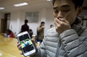 A man who only gave his surname Zhao shows a photo of his girlfriend Pan Haiqin who was killed in the deadly stampede in Shanghai, China, Friday, Jan. 2, 2015. AP