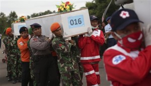 Members of the National Search And Rescue Agency and Indonesian soldier carry coffins containing bodies of the victims aboard AirAsia Flight 8501 to transfer to Surabaya at the airport in Pangkalan Bun, Indonesia, Friday, Jan. 2, 2015. The investigation into the AirAsia crash has turned to the ocean floor, with more sonar equipment and metal detectors deployed today to scour the seabed for wreckage, including the plane's black boxes. (AP Photo/Achmad Ibrahim)