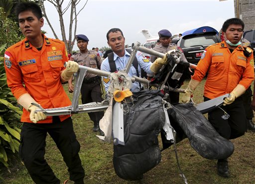 National Search and Rescue Agency personnel carry the seats of AirAsia Flight 8501 after being airlifted by a U.S. Navy helicopter, at the airport in Pangkalan Bun, Indonesia, Monday, Jan. 5, 2015.  AP
