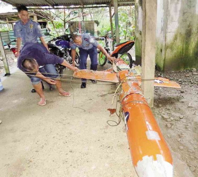 POLICEMEN in Santa Ana town in Cagayan province secure the wreckage of an aerial target drone said to be owned by the United States military.   PHOTO COURTESY OF SANTA ANA POLICE 