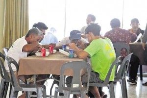 SOME of the fishermen rescued by the Palawan police eat their lunch in a budget hotel in Cebu City after their ordeal.  JUNJIE MENDOZA/ CEBU DAILY NEWS 