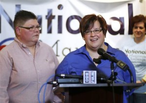 April DeBoer, right, speaks as her partner Jayne Rowse, left, looks on during a news conference in Ferndale, Mich., Friday, Jan. 16, 2015. Setting the stage for a potentially historic ruling, the Supreme Court said Friday that it will decide whether same-sex couples nationwide have a right to marry under the Constitution. (AP Photo/Paul Sancya)