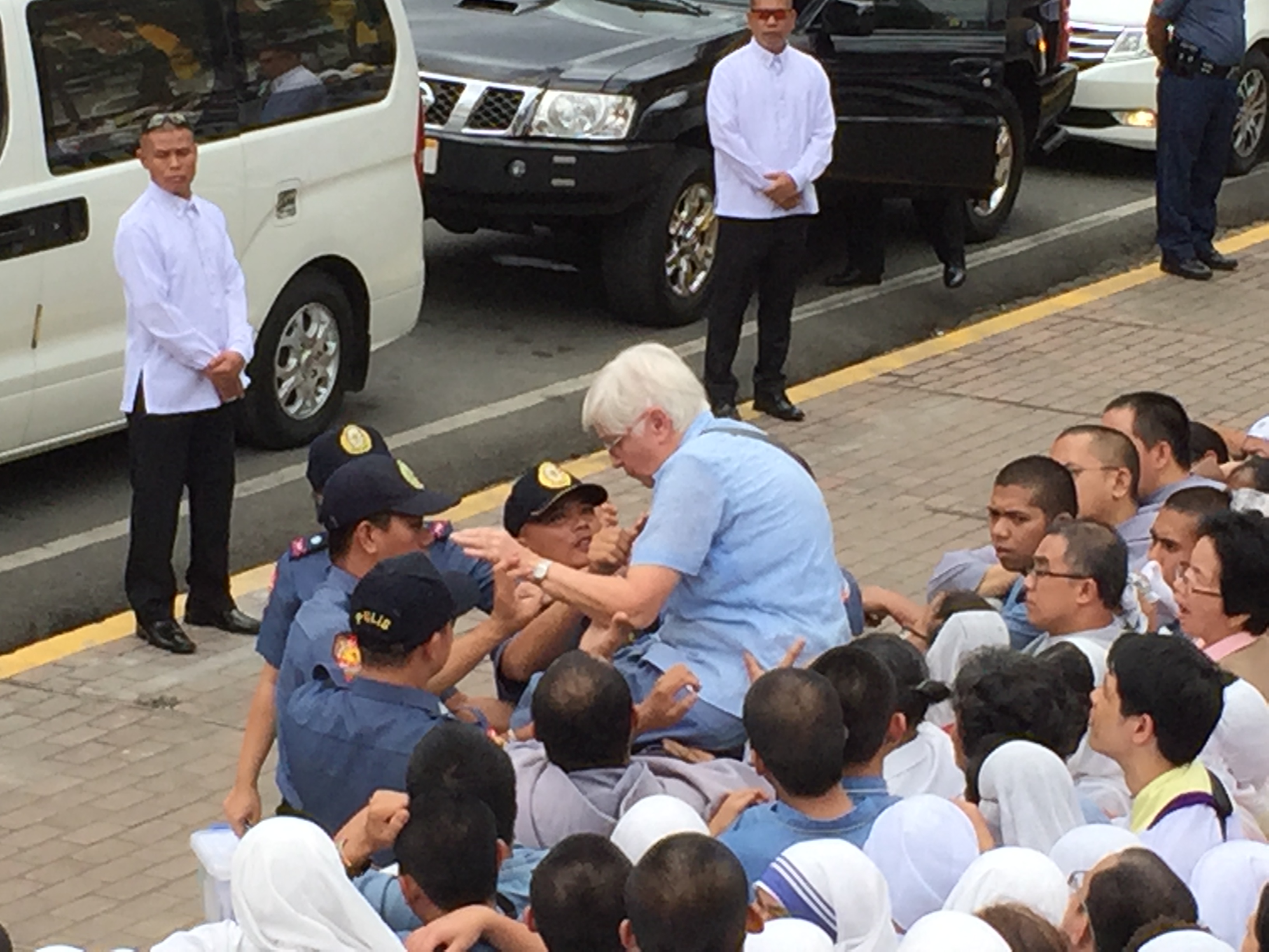 Policemen assist an elderly woman during one of the papal events in Manila. TETCH TORRES-TUPAS