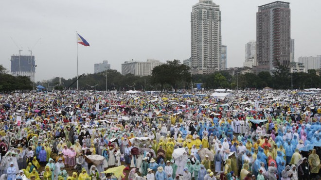 Thousands of the faithful wait in the rain at Rizal Park where Pope Francis will celebrate his final Mass in Manila, Philippines, Sunday, Jan. 18, 2015. Millions filled Manila's main park and surrounding areas for Pope Francis' final Mass in the Philippines on Sunday, braving a steady rain to hear the pontiff's message of hope and consolation for the Southeast Asian country's most downtrodden and destitute. (AP Photo/Bullit Marquez)