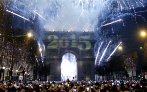 Revelers photograph fireworks over the Arc de Triomphe as they celebrate the New Year's Eve on the Champs Elysees avenue in Paris, France, Thursday, Jan. 1, 2015. (AP Photo/Christophe Ena)