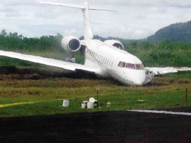 Two blue guards secure the private plane that remains stuck at the grassy portion of the runway at the Daniel Z. Romualdez Airport in Tacloban City, Leyte. Connie E. Fernandez/ Inquirer Visayas 