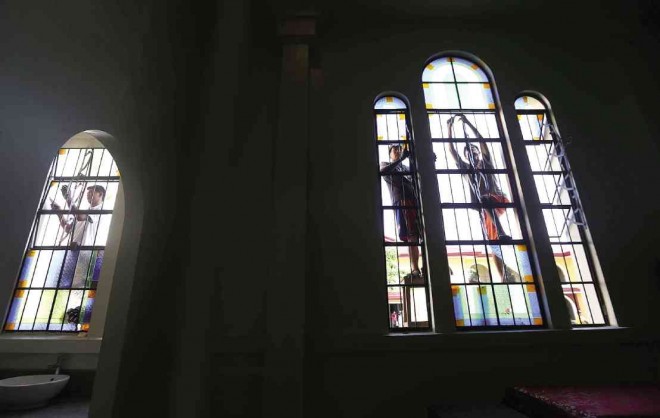 Workers strip off broken stained glass panels from church windows in Palo Cathedral which were damaged by Supertyphoon “Yolanda” in preparation for Pope Francis’ visit.  LYN RILLON  